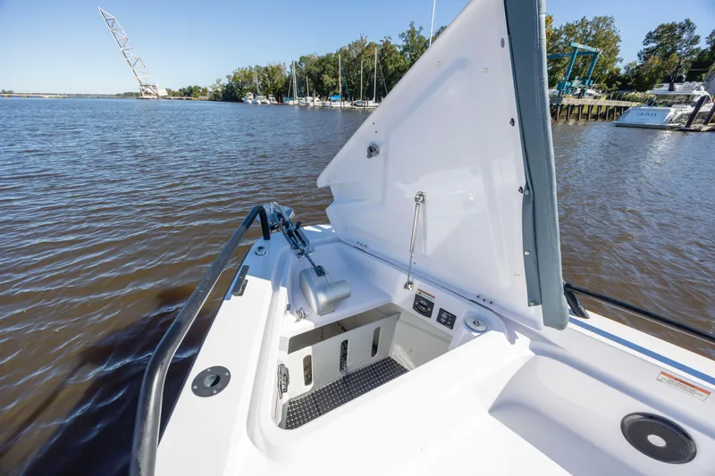  Yacht Photos Pics 2022 Axopar 37 Sun Top boat with open storage compartment on a calm river.