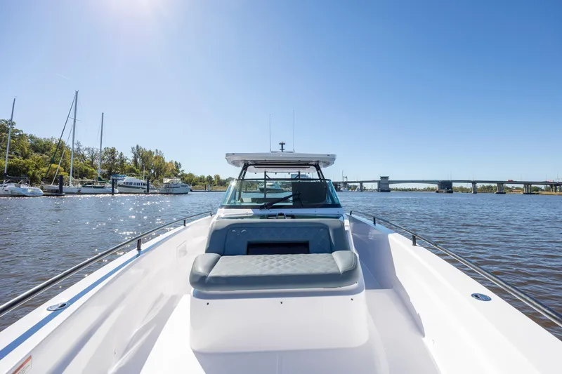  Yacht Photos Pics 2022 Axopar 37 Sun Top boat on a sunny day, docked near a marina.