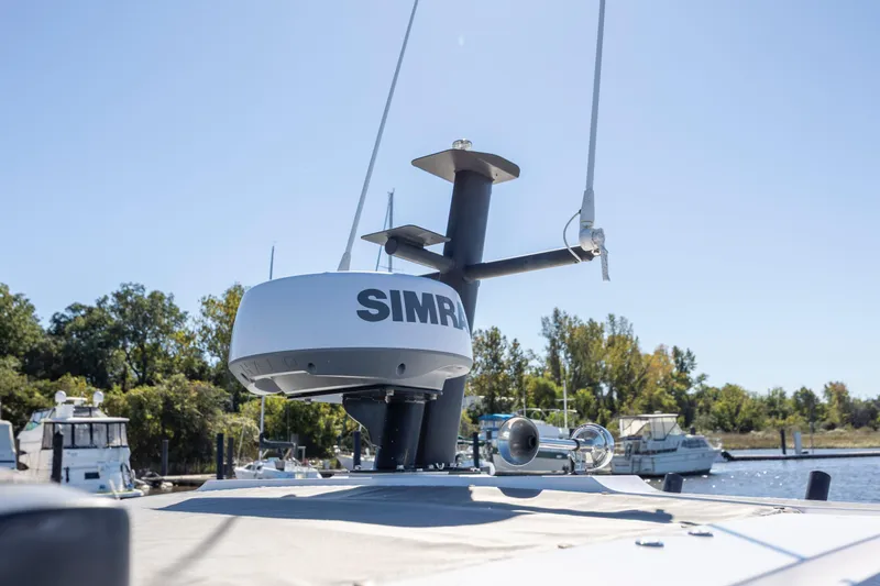  Yacht Photos Pics Radar equipment on 2022 Axopar 37 Sun Top boat, docked near trees and other boats.