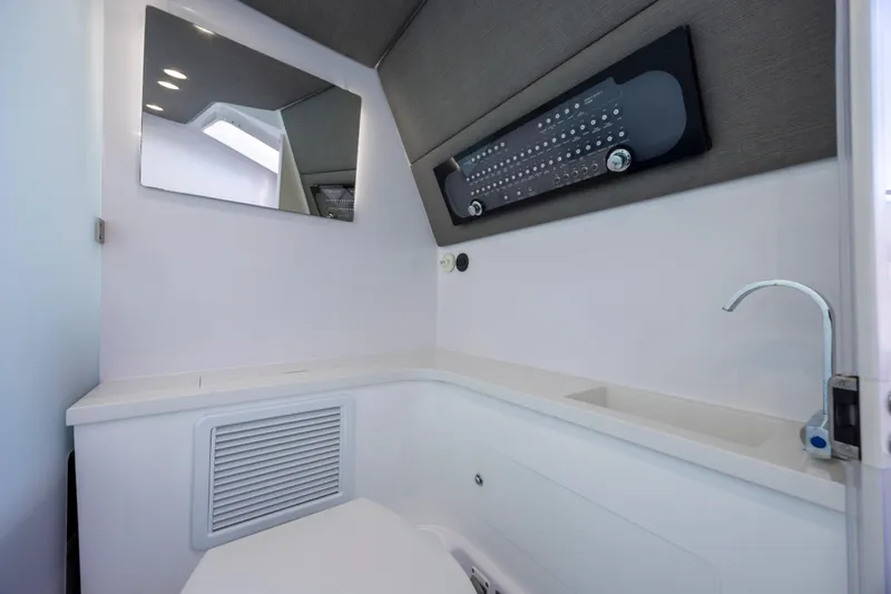  Yacht Photos Pics Interior of 2022 Axopar 37 Sun Top boat bathroom with modern fixtures and mirror.