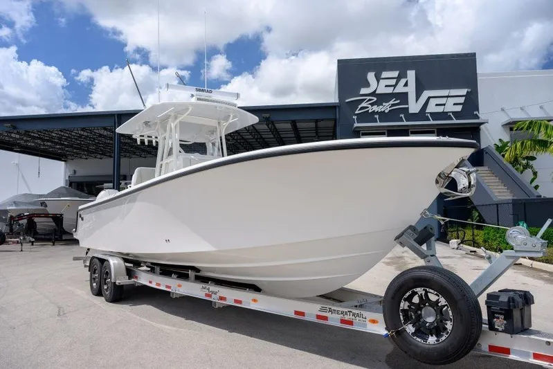  Yacht Photos Pics 2025 SeaVee 320B boat on trailer at SeaVee dealership under blue sky.