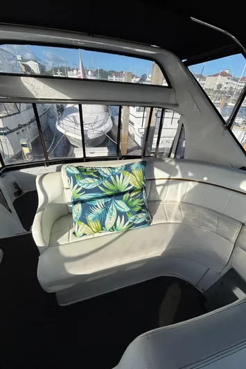 Busy Living Yacht Photos Pics 2001 Carver 396 Aft Cabin MY interior with white seating and tropical cushion.