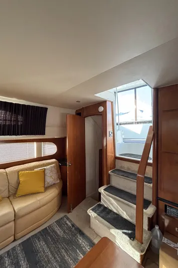 Busy Living Yacht Photos Pics Interior of 2001 Carver 396 Aft Cabin MY with beige sofa and wooden stairs.