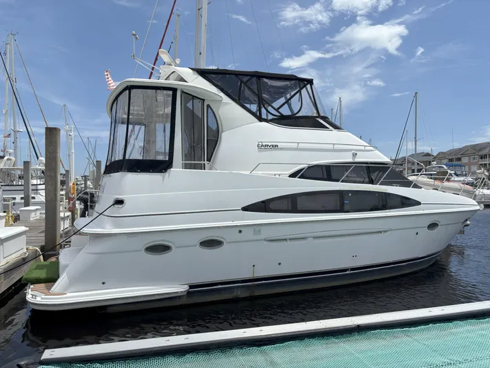 Busy Living Yacht Photos Pics 2001 Carver 396 Aft Cabin MY yacht docked at marina under clear sky.