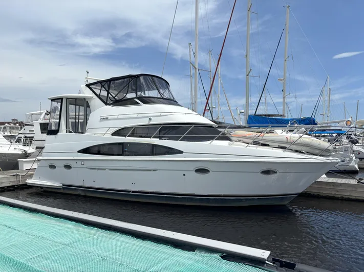 Busy Living Yacht Photos Pics 2001 Carver 396 Aft Cabin MY yacht docked at marina under clear sky.