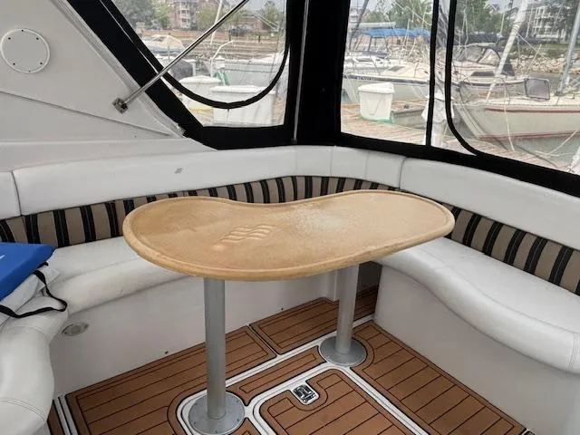 Yacht Photos Pics 2007 Four Winns 378 Vista yacht interior with curved seating and wooden table.