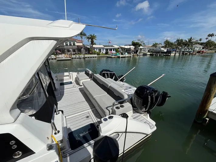 Namaste Yacht Photos Pics 2018 Aquila 36 Sport boat docked in a scenic marina under a clear blue sky.