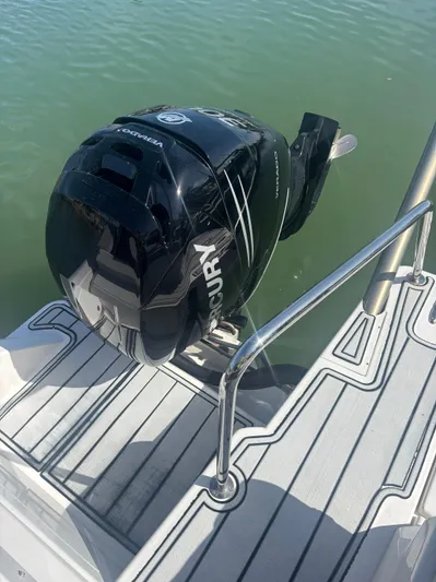 Namaste Yacht Photos Pics Outboard motor on 2018 Aquila 36 Sport boat, docked on calm water.