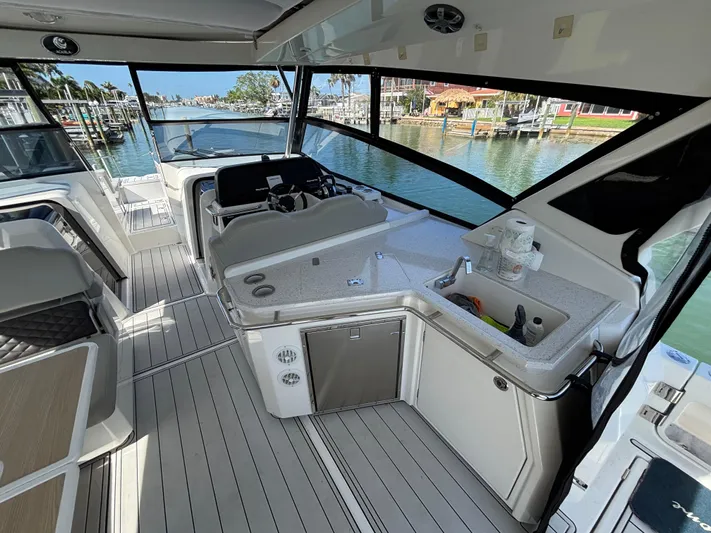 Namaste Yacht Photos Pics Interior view of 2018 Aquila 36 Sport yacht with modern helm and kitchenette.