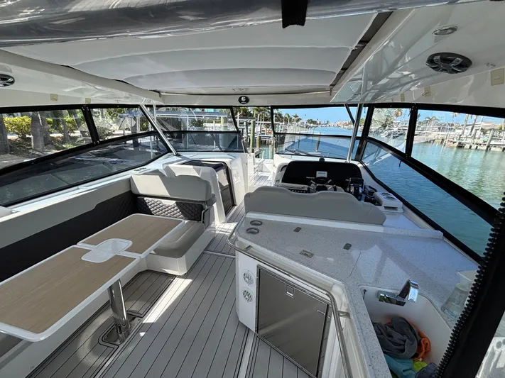 Namaste Yacht Photos Pics Interior of 2018 Aquila 36 Sport yacht with seating and helm, docked at marina.