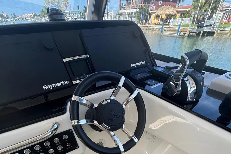 Namaste Yacht Photos Pics Steering console of 2018 Aquila 36 Sport with Raymarine electronics and waterfront view.