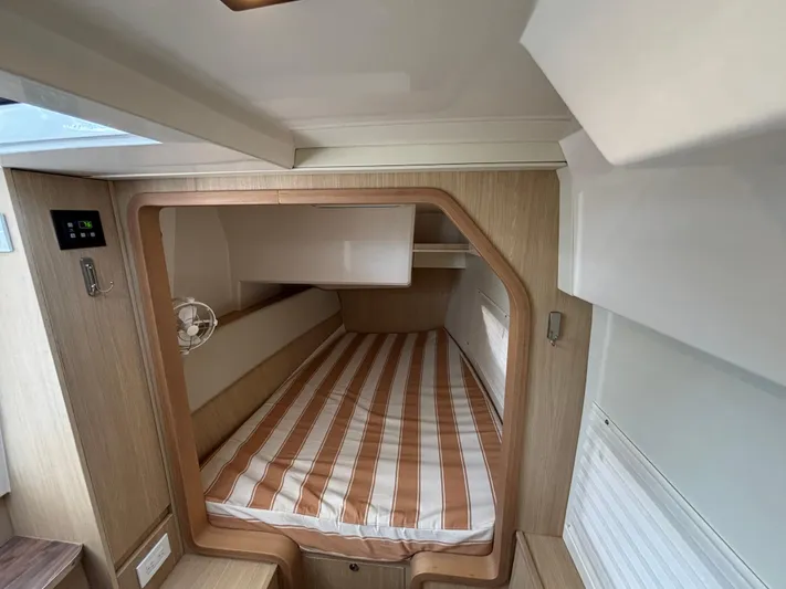 Namaste Yacht Photos Pics Cabin interior of 2018 Aquila 36 Sport with striped bedding and wooden accents.