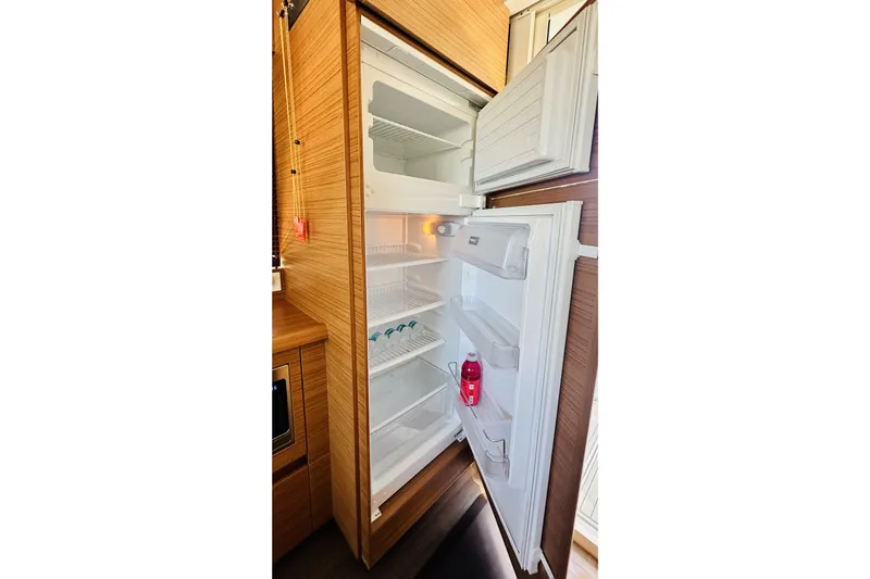 Least Expensive 39 Hybrid In The Country Yacht Photos Pics Open refrigerator inside 2021 Greenline 39 Hybrid yacht, showcasing spacious interior and wooden cabinetry.