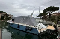 Nimbus W11 2023 boat docked, covered with a tarp, in a serene marina setting.