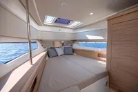 Luxurious interior of 2023 Nimbus W11 yacht with spacious bed and ocean view.