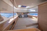 Luxurious interior of 2023 Nimbus W11 yacht with spacious bed and scenic windows.
