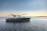2023 Nimbus W11 yacht cruising on calm waters under a clear sky.