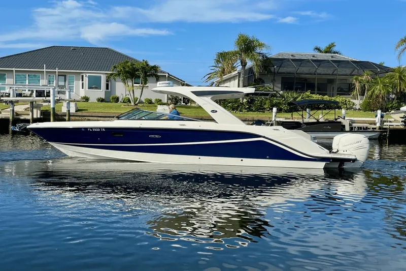  Yacht Photos Pics 2023 Sea Ray 310 SLX-OB boat on calm water near waterfront homes.