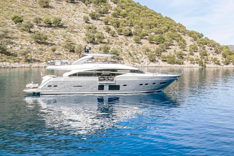 Lady Parisa Yacht Photos Pics Luxurious 2014 Princess 88 Motor Yacht on serene blue waters near a lush hillside.