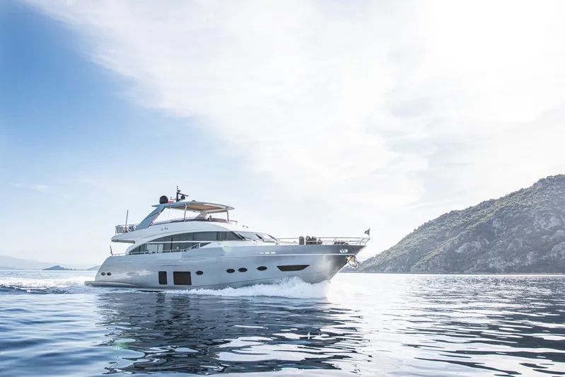 Lady Parisa Yacht Photos Pics 2014 Princess 88 Motor Yacht cruising on serene waters near a rocky coastline.