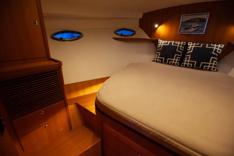  Yacht Photos Pics Cozy cabin interior of 2018 Hylas M44 yacht with elegant wood finish and ambient lighting.