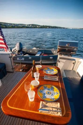  Yacht Photos Pics 2018 Hylas M44 yacht with dining setup, American flag, and scenic ocean view.