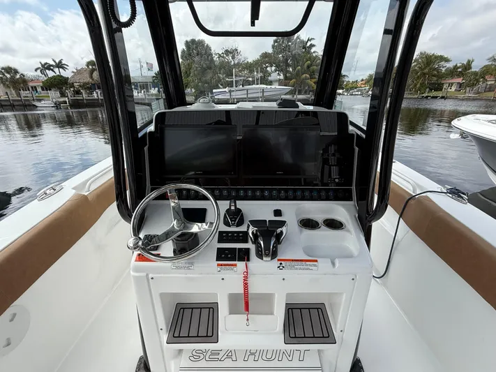  Yacht Photos Pics 2023 Sea Hunt Gamefish 30 helm with modern controls and scenic waterfront view.