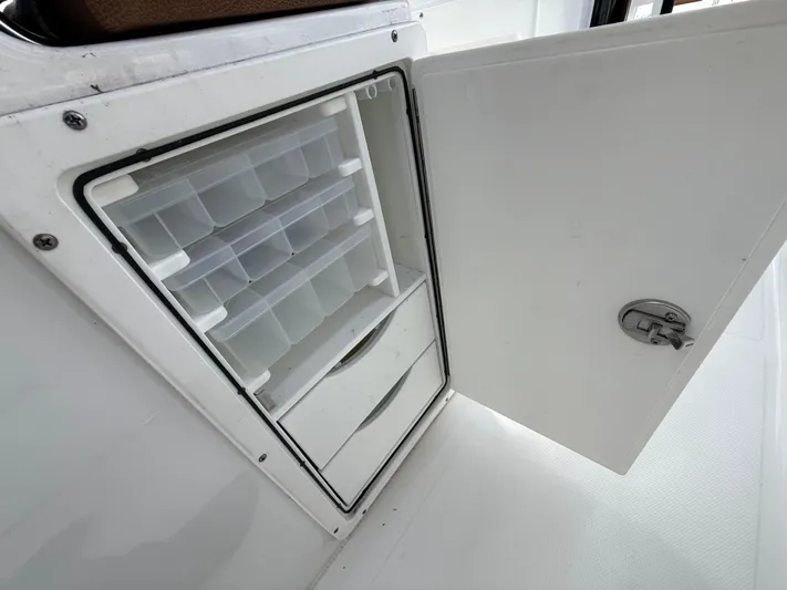  Yacht Photos Pics 2023 Sea Hunt Gamefish 30 storage compartment with open door and organized shelves.