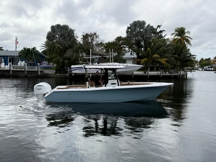  Yacht Photos Pics 2023 Sea Hunt Gamefish 30 boat cruising on a calm waterway near palm trees.