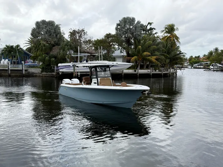  Yacht Photos Pics 2023 Sea Hunt Gamefish 30 boat on a calm waterway, surrounded by lush greenery.