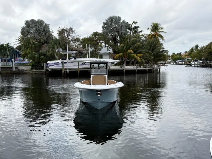  Yacht Photos Pics 2023 Sea Hunt Gamefish 30 boat on a calm waterway, surrounded by lush greenery.