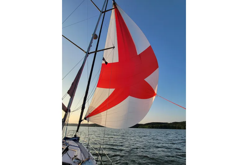 Scuba Duo Yacht Photos Pics Sailboat with red and white spinnaker on a Hunter 41 AC, 2004 model, at sunset.