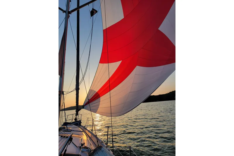 Scuba Duo Yacht Photos Pics Sailing on a 2004 Hunter 41 AC yacht with vibrant red and white sails at sunset.