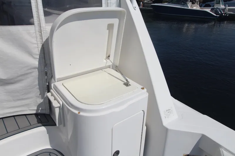 Pescador Yacht Photos Pics Open storage compartment on 2013 Cabo 40 Hardtop Express boat, docked by the water.