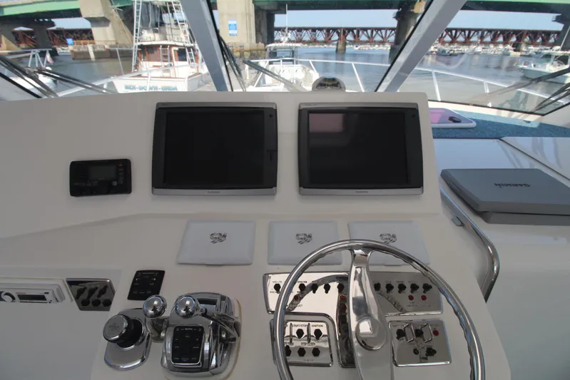 Pescador Yacht Photos Pics Helm of 2013 Cabo 40 Hardtop Express with dual screens and controls, docked near a bridge.