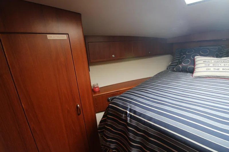 Pescador Yacht Photos Pics Cozy cabin interior of 2013 Cabo 40 Hardtop Express with striped bedding and wooden cabinetry.