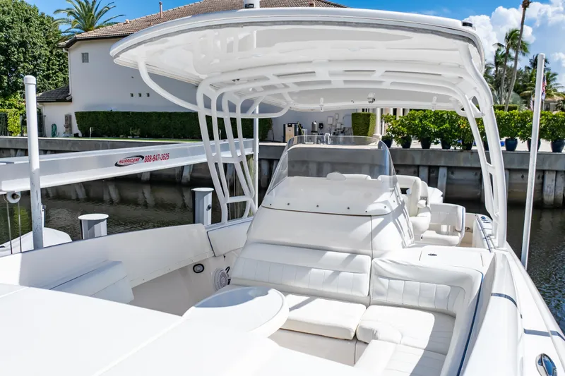  Yacht Photos Pics 2015 Intrepid 327 Cuddy boat with sleek white design docked by waterfront.