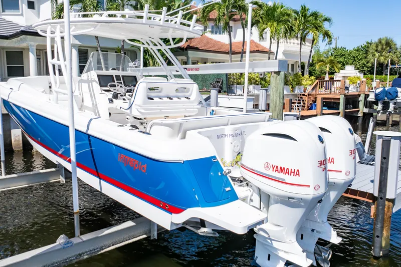  Yacht Photos Pics 2015 Intrepid 327 Cuddy boat with Yamaha engines docked near waterfront home.