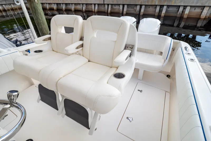  Yacht Photos Pics 2015 Intrepid 327 Cuddy boat interior with white cushioned seating and cup holders.