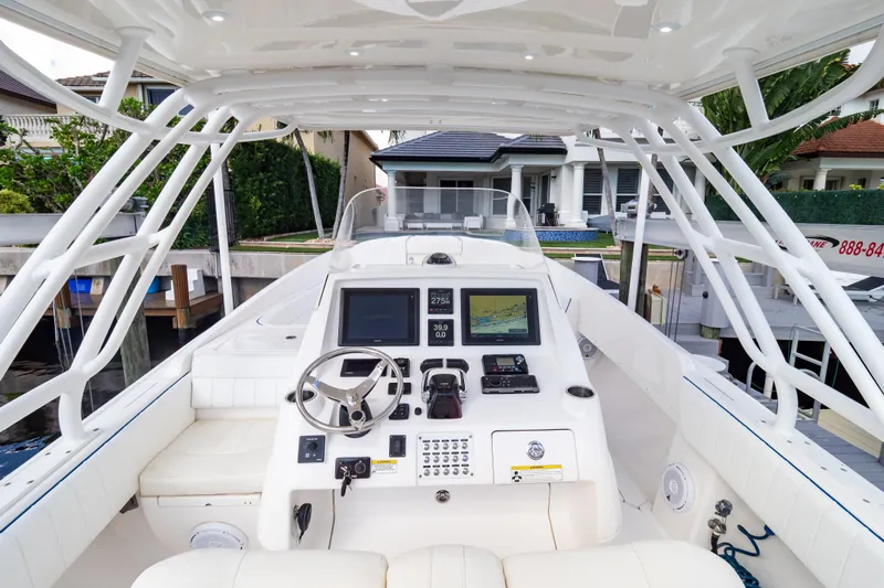  Yacht Photos Pics 2015 Intrepid 327 Cuddy boat cockpit with steering wheel and navigation displays.