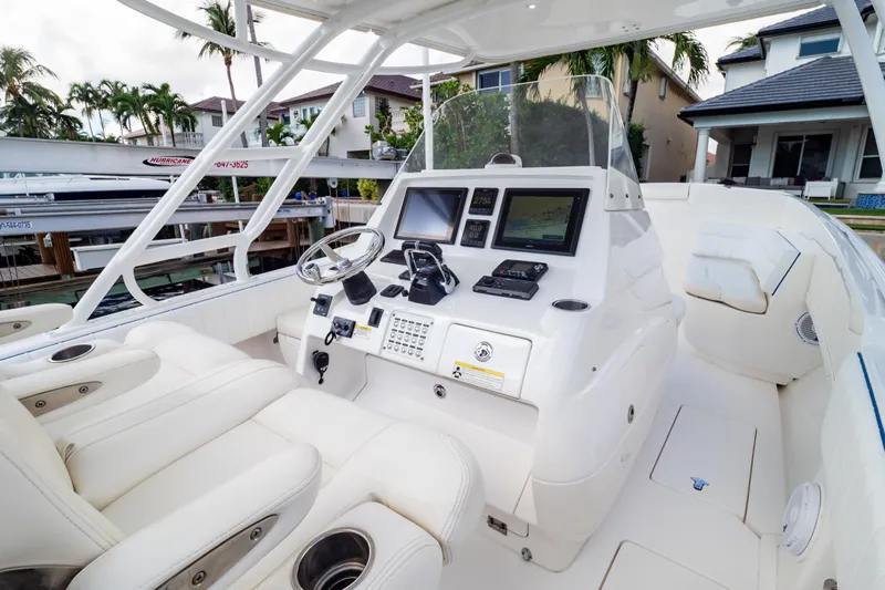  Yacht Photos Pics 2015 Intrepid 327 Cuddy boat interior with modern navigation system and white seating.