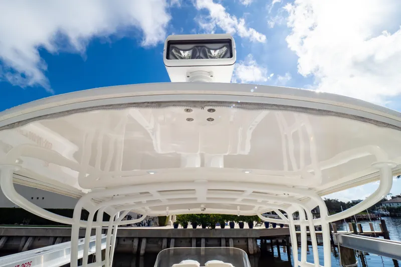  Yacht Photos Pics 2015 Intrepid 327 Cuddy boat with sleek white canopy under blue sky.