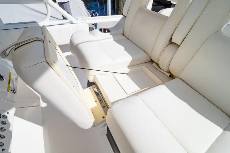  Yacht Photos Pics 2015 Intrepid 327 Cuddy boat interior with white cushioned seating and storage compartment.