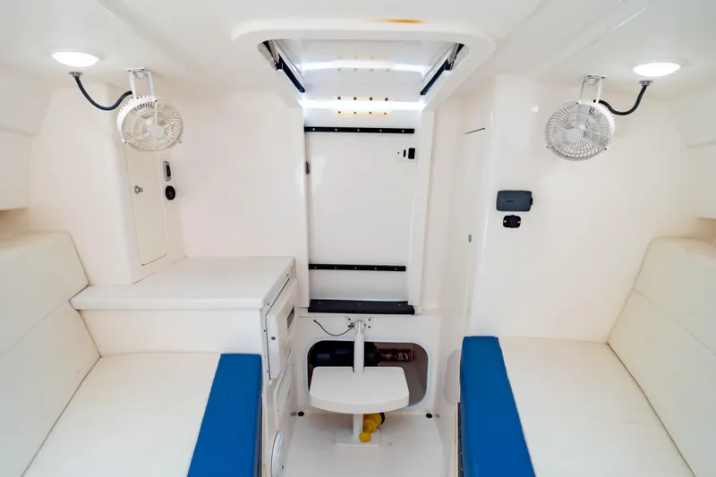  Yacht Photos Pics Interior of a 2015 Intrepid 327 Cuddy boat, featuring white seating and compact design.