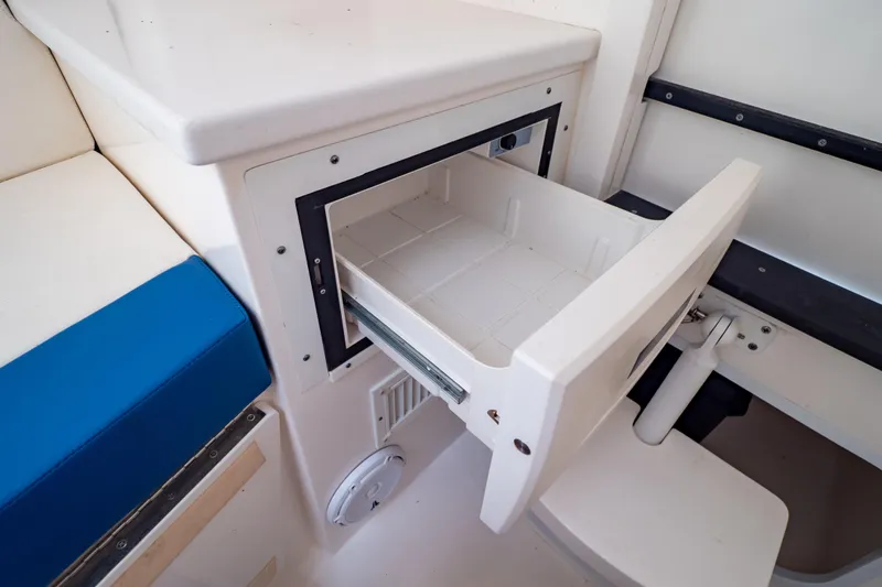  Yacht Photos Pics Open storage compartment on 2015 Intrepid 327 Cuddy boat, featuring white and blue seating.