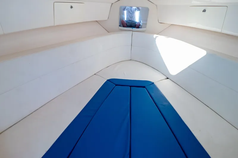  Yacht Photos Pics 2015 Intrepid 327 Cuddy interior with blue cushions and storage compartments.