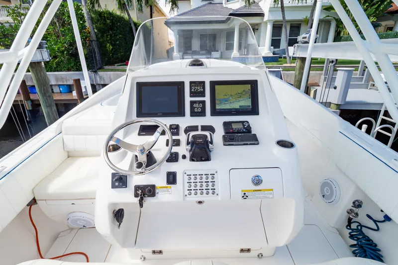  Yacht Photos Pics 2015 Intrepid 327 Cuddy boat cockpit with steering wheel and navigation displays.