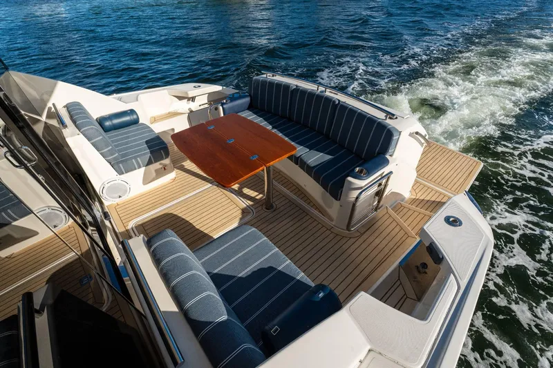 Down Time Yacht Photos Pics 2015 Tiara Yachts C44 Coupe with elegant seating and wooden table on deck.