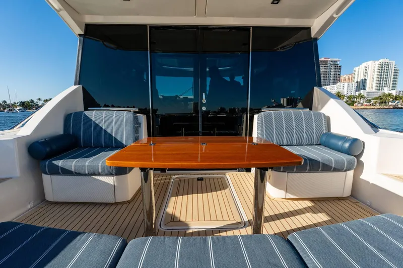 Down Time Yacht Photos Pics 2015 Tiara Yachts C44 Coupe deck with seating and table, overlooking waterfront skyline.