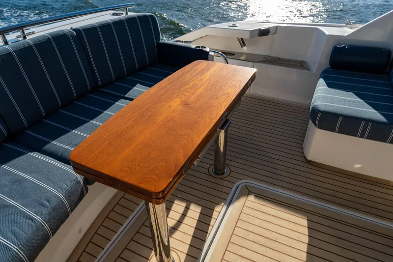 Down Time Yacht Photos Pics Luxury seating area on 2015 Tiara Yachts C44 Coupe with wooden table and ocean view.